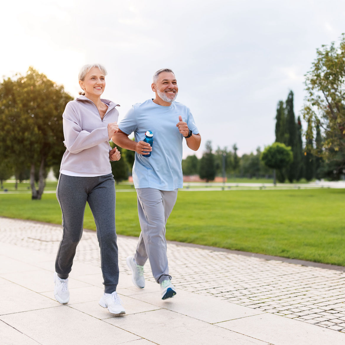 A happy couple jogging together in a park anti-aging, longevity optimization