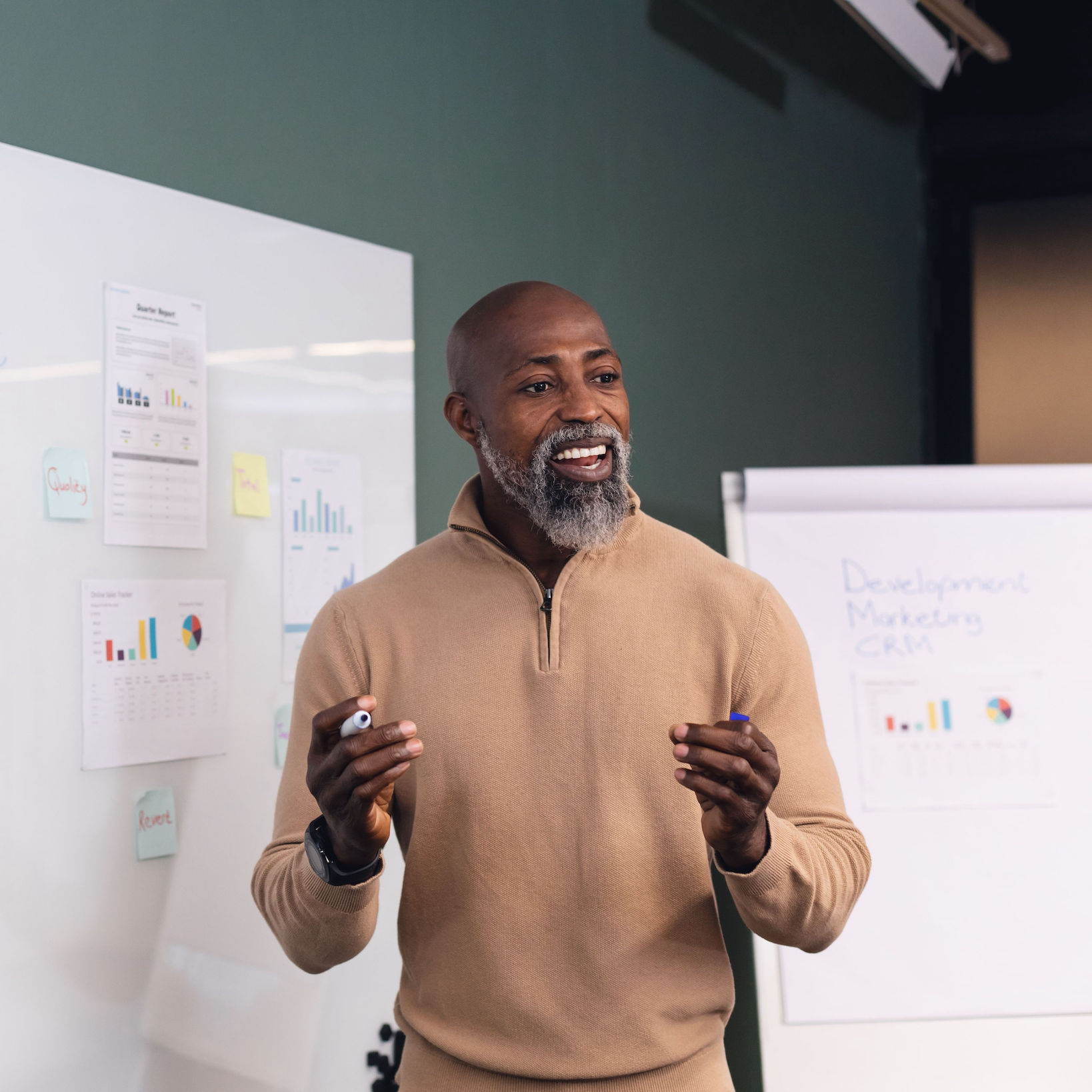 A confident man explaining stuff in front of a whiteboard.