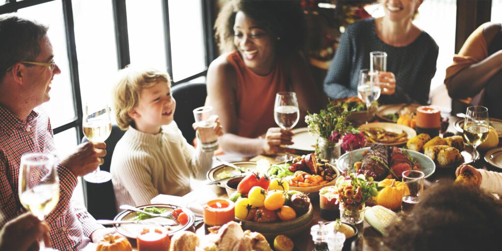 Family enjoying a toast from a child expressing thanks before a meal