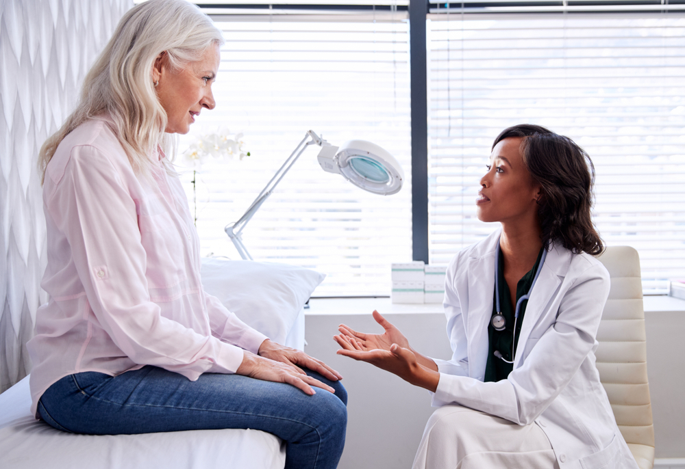 Doctor compassionately explaining a treatment to older female patient